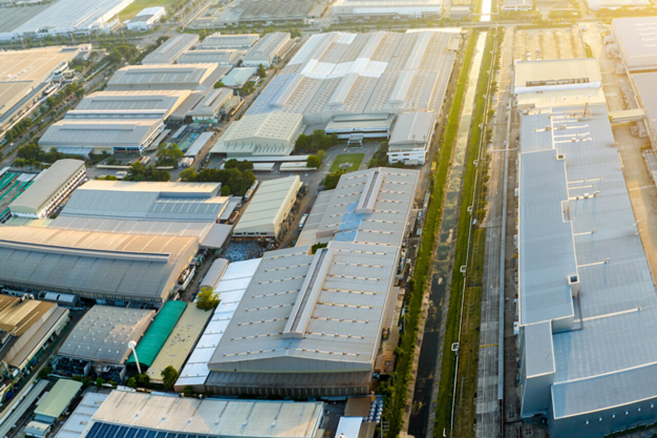An aerial view of a large-scale production plant with factory buildings and logistics areas, serving as an example of modern factory planning.