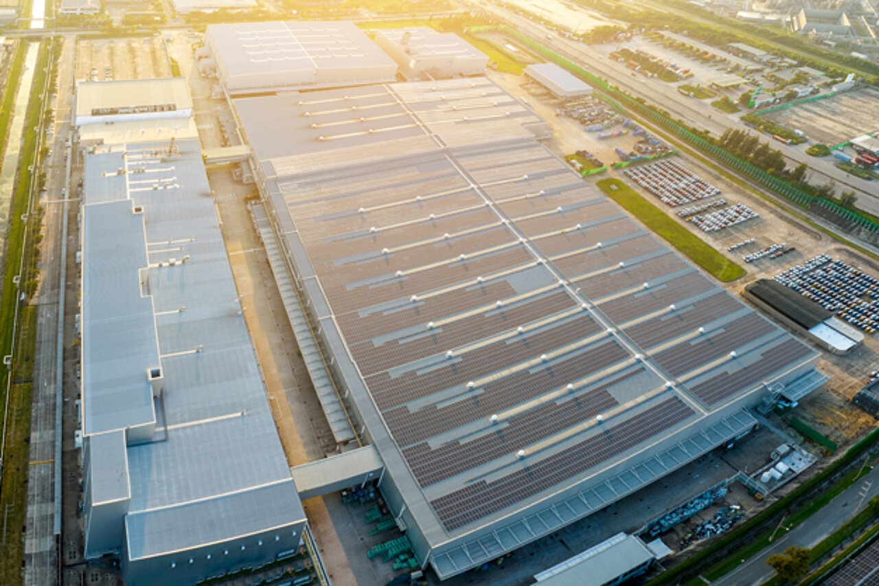 An aerial view of a large-scale production plant with factory buildings and logistics areas, serving as an example of modern factory planning.